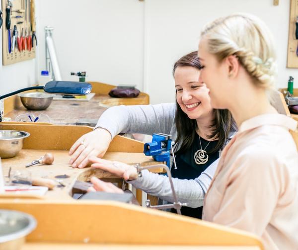 London Jewellery School founder Jessica Rose with a student at a jewellery workbench in the London Jewellery School 10th birthday celebration post