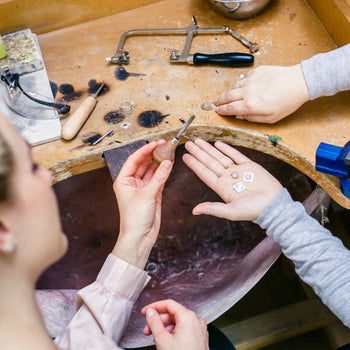 Jewelers at workbench with tools for optimization consultants.